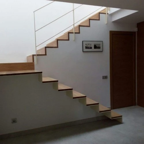 Escala de traçat recte amb graons de fusta i una barana de línies lleugeres.